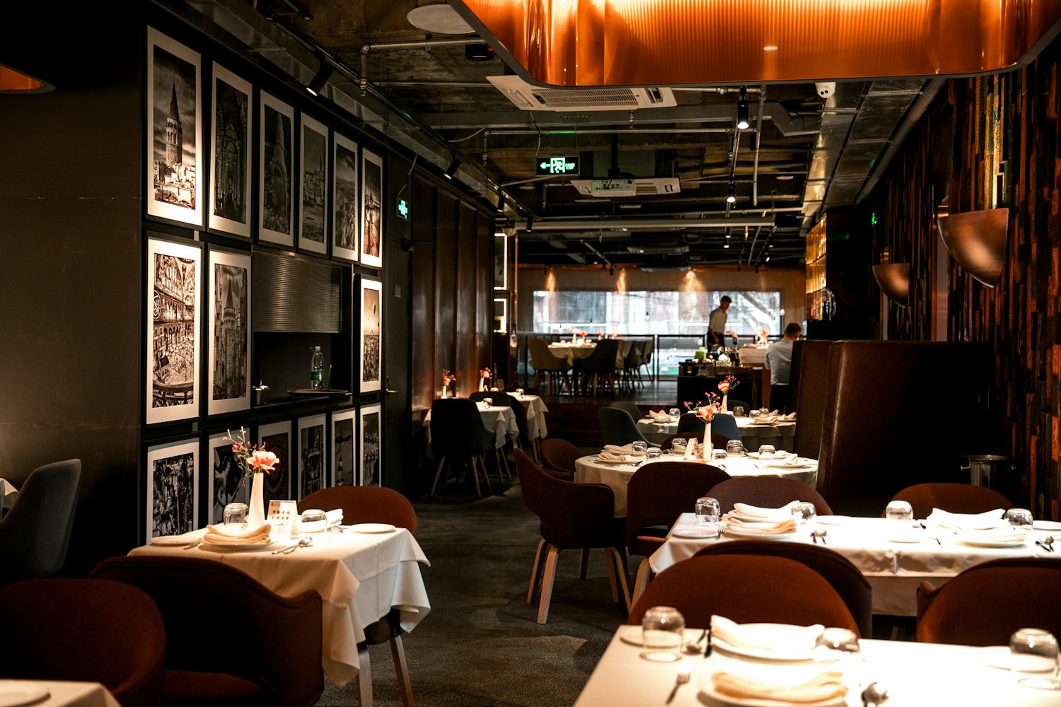 The back room set for a private dinner, with framed prints along the wall